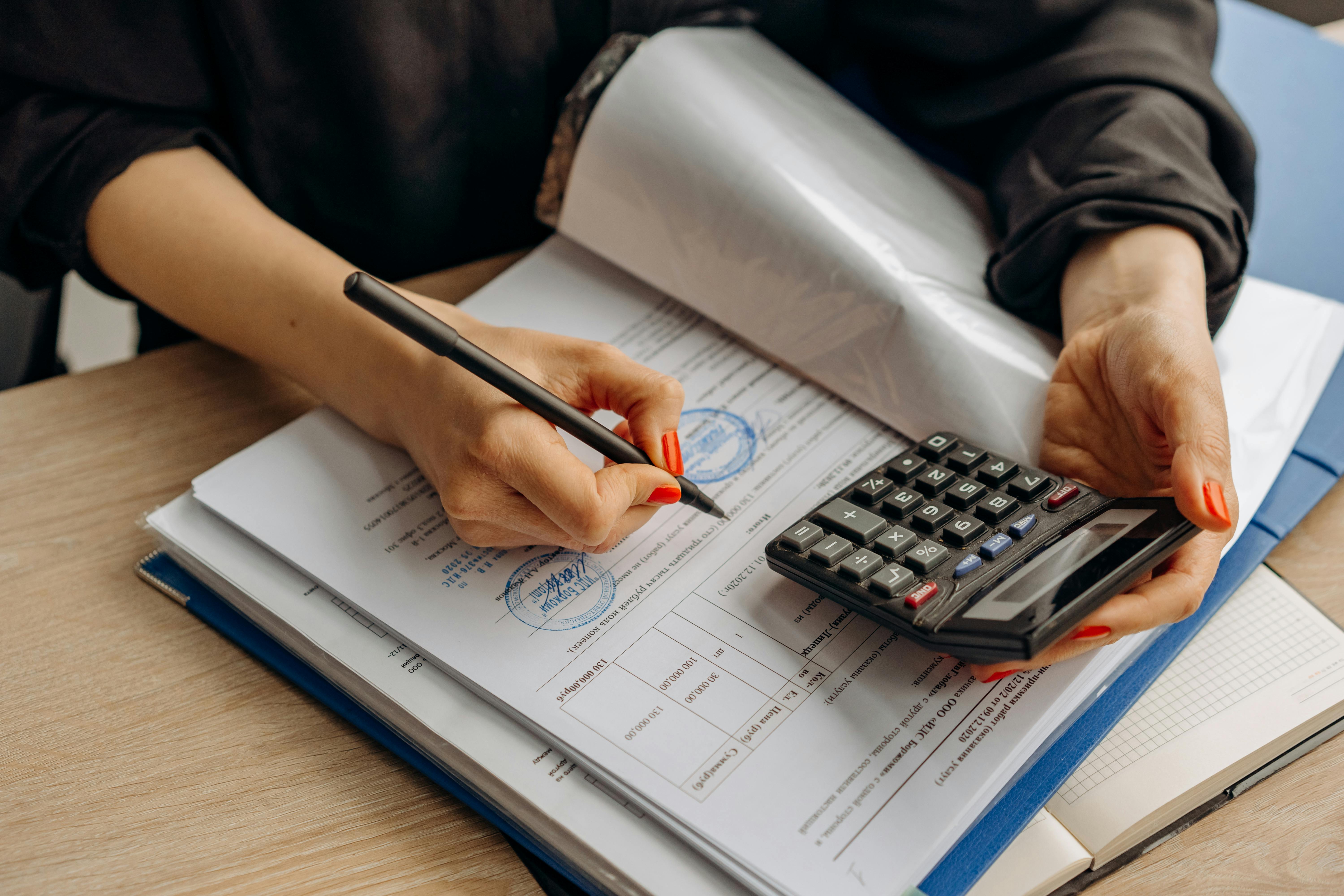 Person completing official tax identification forms with calculator